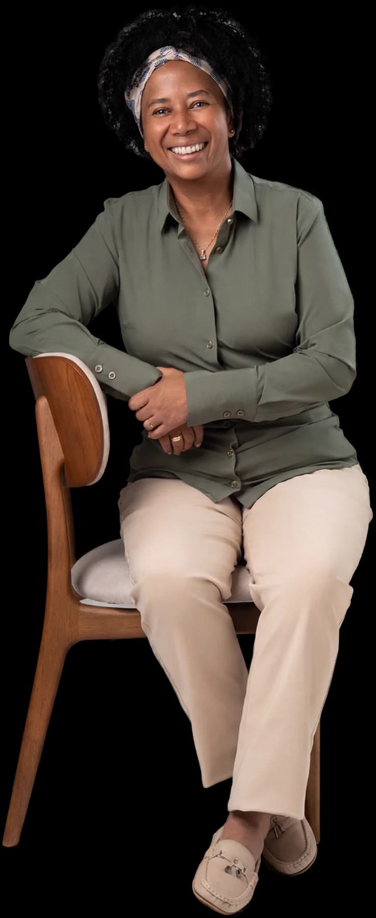 Silvia Cristina sentada, de roupa verde-oliva, em foto de estúdio.