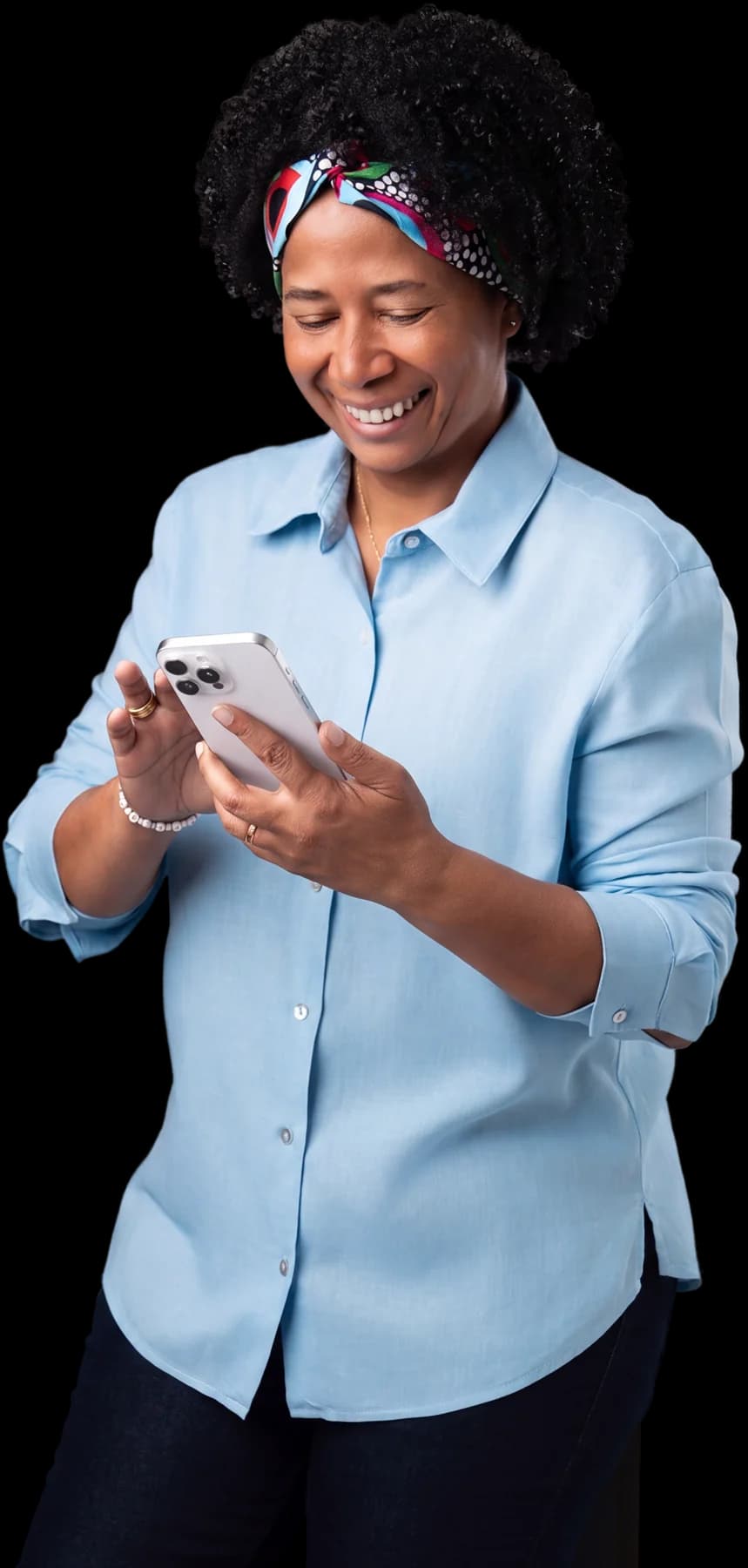 Silvia Cristina de camisa azul-clara, sorrindo com o celular na mão, em foto de estúdio.