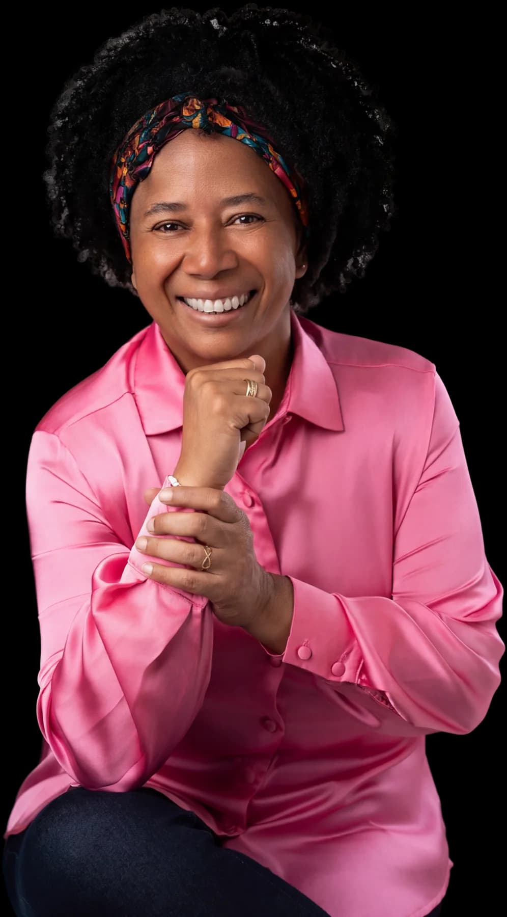 Silvia Cristina de camisa rosa, com o punho sob o queixo, em foto de estúdio.